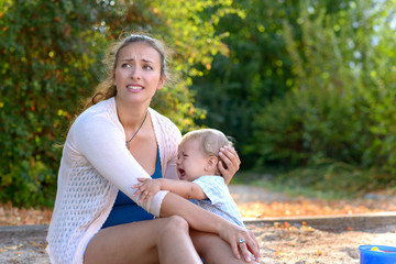 Stressed young mother comforting her crying son