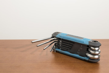 Blue multitool allen keys on a wood table