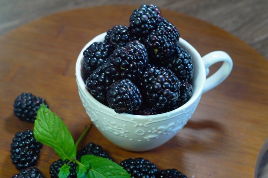 Close-up of  juicy blackberries in a bowl on rustic table
