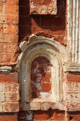 Fototapeta na wymiar A fragment of an old brick wall with oval window - Russia, Mozhaisk Kremlin, region landmark Novo-Nikolsky Cathedral on a summer day