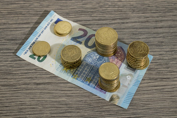 Currency, shiny euro coins and banknote on a decorated wood table