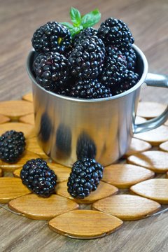 Close-up of  juicy blackberries in a bowl on rustic table
