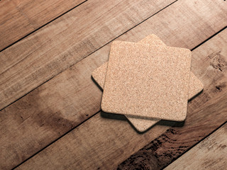 Two square Cork beer coasters Mockup lies on the wooden table - obrazy, fototapety, plakaty