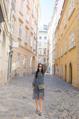 Fototapeta na wymiar Woman walking in city. Young attractive tourist outdoors in european city