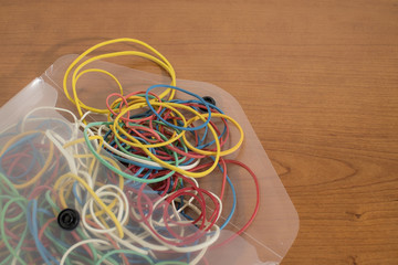 Set colored rubber bands in a envelope in a wood table