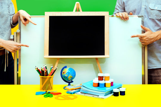 empty chalkboard hand School notebook board male female paint globe pencils table four show yellow blue