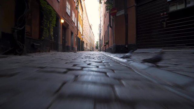 A steady gimbal footage low to the ground in a dark alley in the Old Town of Stockholm Sweden. Early morning, empty streets in the medieval town. Beautiful historic scenery in Gamla Stan.