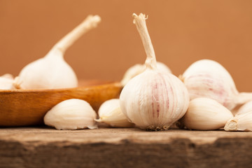 Garlic on old wooden table with brown background.