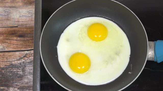 Cooking sunny side up eggs for breakfast. Close up slider shot.