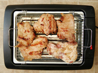 Delicious pieces of meat with spices on the electric grill