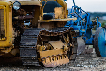 Fototapeta premium Caterpillar Old Tractor in a Field during Sunset