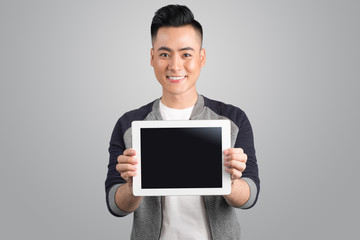 Confident young asian businessman showing digital tablet screen.