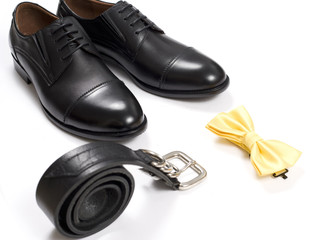 Close up of modern man accessories. bow tie, leather shoes, belt on white background.