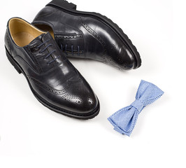 Close up of modern man accessories. bow tie, leather shoes, belt on white background.