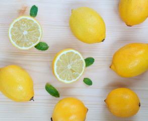 Fresh background with juicy lemons and mint leaves on light wood, top view