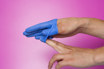 Doctor hand glove shows on purple background. Infection control concept.