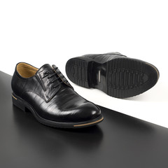 Classic male black leather shoes isolated on a white and black