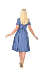 full length portrait of blonde girl wearing blue dress. standing pose with back to the camera. isolated on white  studio background.