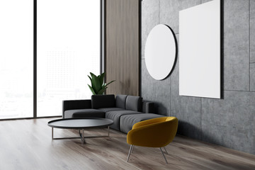 Navy sofas standing around a white coffee table in a concrete living room with posters on the walls. Side view 3d rendering mock up