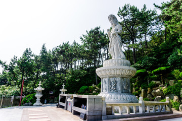 Guanyin or Guan Yin Goddess of Mercy white stone statue on the top of the hill at Haedong Yonggungsa Temple in Busan, South Korea.
