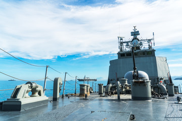 Navy ship sails in the sea show its bow including main gun.