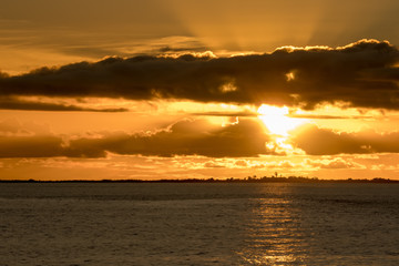 Beautiful sunset at the coast with ray of light spotted.