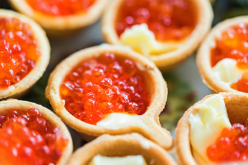 Tartlets with red caviar and butter close