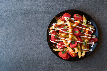 Homemade Peruvian Salchipapa Fries with Sausage Slices, Ketchup and Mayonnaise.