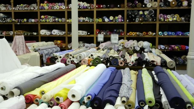 View of cloth rolls of different colors and patterns on shelves in fabric store