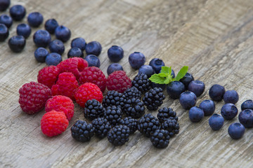 mix of blackberries, raspberries, blueberry on old wooden table background. top view with copy space