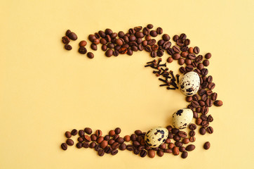 three quail eggs and a sticks of cinnamon in the middle of the circle of coffee beans on a yellow background