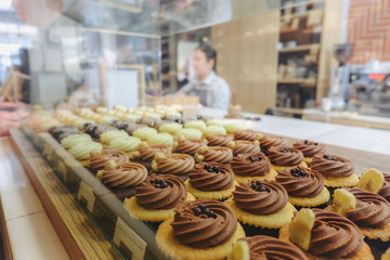 Many flavours cupcakes with testy cream on the bar