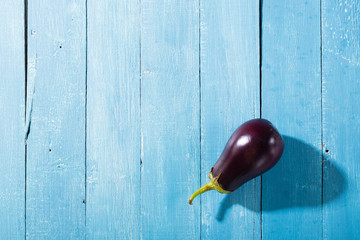 eggplant with shade on blue wood table