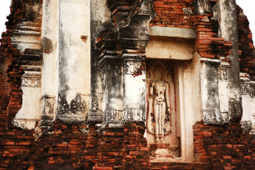 Ancient Buddha statue attached on old brick wall of pagoda and Low-relief art of Buddha in the temple of Thailand