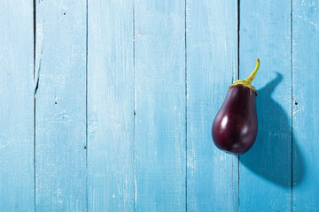 eggplant with shade on blue wood table