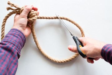 a man cuts a loop from a rope. concept stop suicide