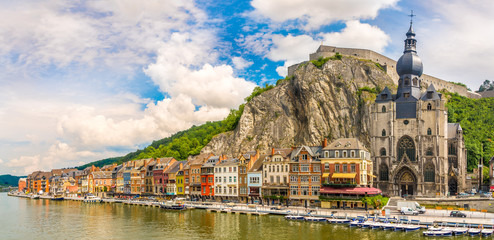 Panoramic vew at the embankment of Meuse river with houses and church of Our Lady Assumption in Dinant - Belgium - obrazy, fototapety, plakaty