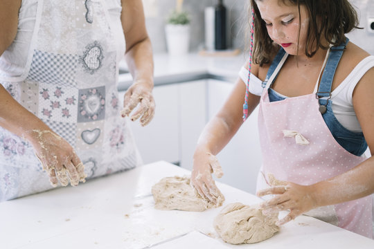 Mother And Daughter Making Bread At Home