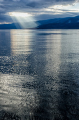 Sun shining through thick cloudy sky, silver lining