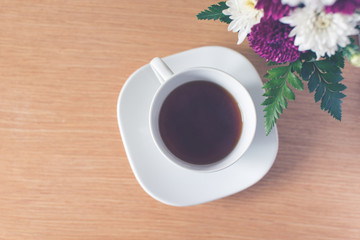 Cup of black teawith flowers on the table.Horizontal