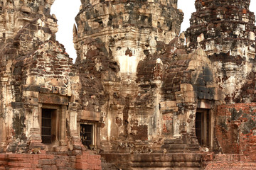Fototapeta premium Ancient Buddha statue attached on old brick wall of pagoda and Low-relief art of Buddha in the temple of Thailand