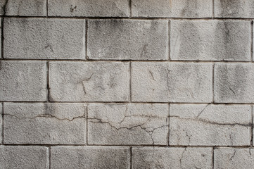 Exterior grey cinder block wall with lines of concrete