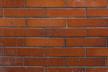 New exterior brown brick wall with lines of concrete