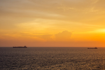 Naklejka na ściany i meble Sunset at the Sea with boat and cloudy sky