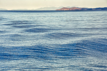 Waves on surface of water with cloudy sky