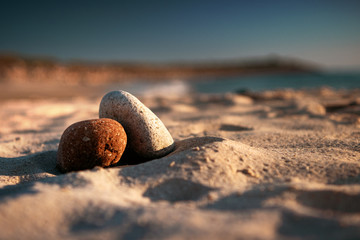 Beautiful peaceful stacked zen stones chill on the sand beach at colorful sunset light. Danish...