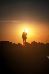 Silhouette of a girl on the beach overlooking the ocean during colorful sunset light with lens flare in summer holidays. Danish Coastline. Lonstrup in North Jutland in Denmark, Skagerrak, North Sea