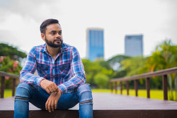 Young Handsome Indian Man In Park Thinking