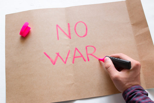 man writes no war text on paper