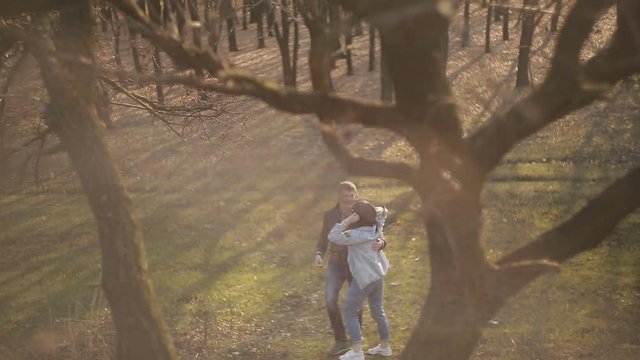 Couple in love walks in the forest at sunset
